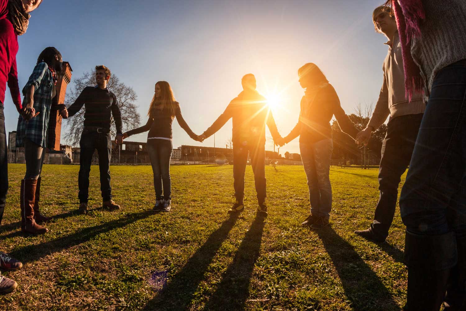 a group of people on the lawn holding hands